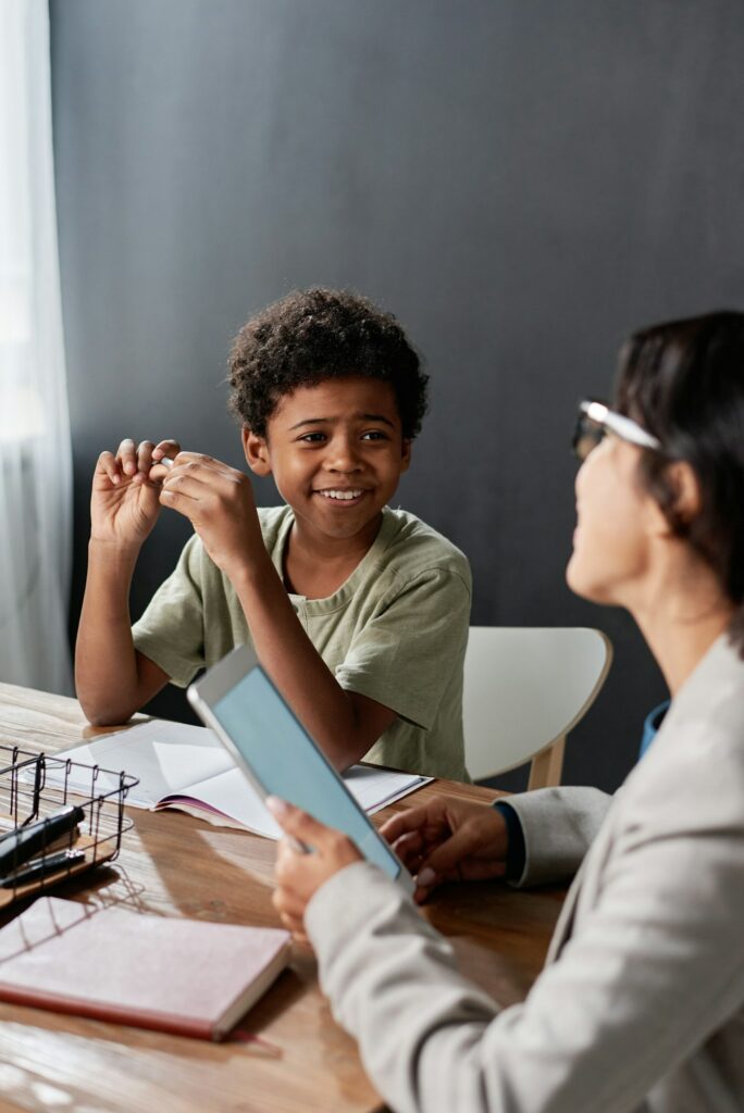 Black student boy talking to tutor