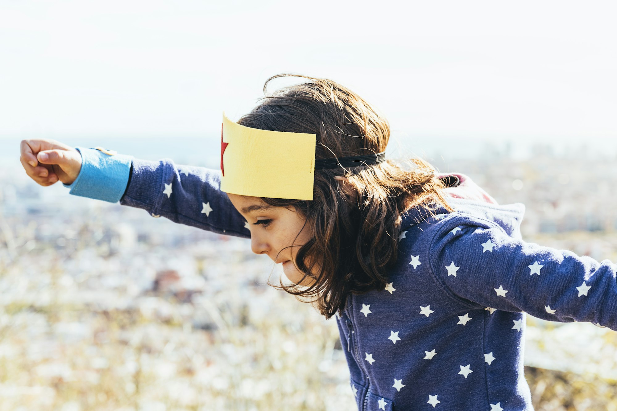 girl flying like a superhero with fist in the air